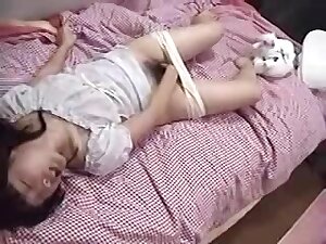 Japanese girl plays with her hairy pussy on her pink bed