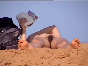 Mature woman lying naked on the beach got her pussy